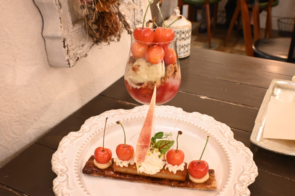 ケーキ部分とグラス部分に分けていただく、食べやすさも考えられたさくらんぼパフェ。マイクロハーブの繊細な飾りも美しい。