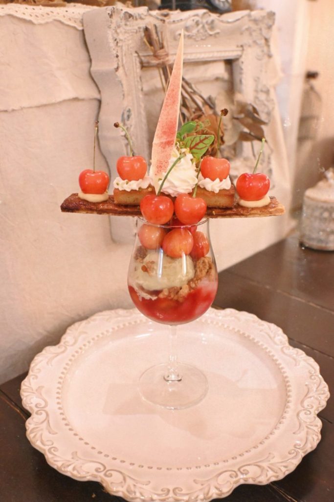繊細なバランスで盛り付けられたcafe tentoのさくらんぼパフェは、アンティークな店内にも映えて見た目も楽しめる逸品。