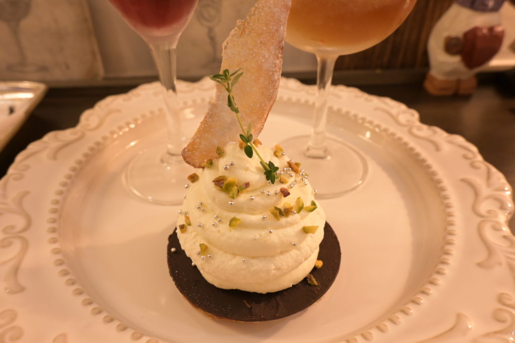 クリスマス限定パフェのケーキ部分のアップ写真。クリームの上に繊細なトッピングが散りばめられている