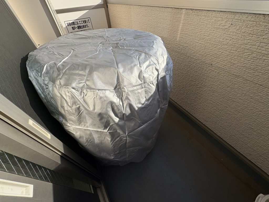 ベランダでタイヤ4本に全体カバーをかけて保管している様子